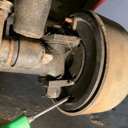 The back of the wheels breaks showing a screw driver inserted into a small hole at an angle.